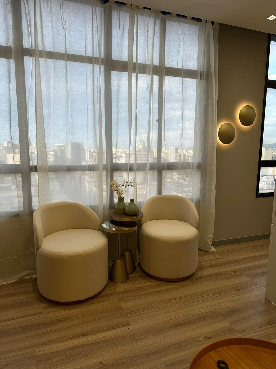 Sala de espera do Studio Jéssica Mendes — poltronas claras e vista para BH