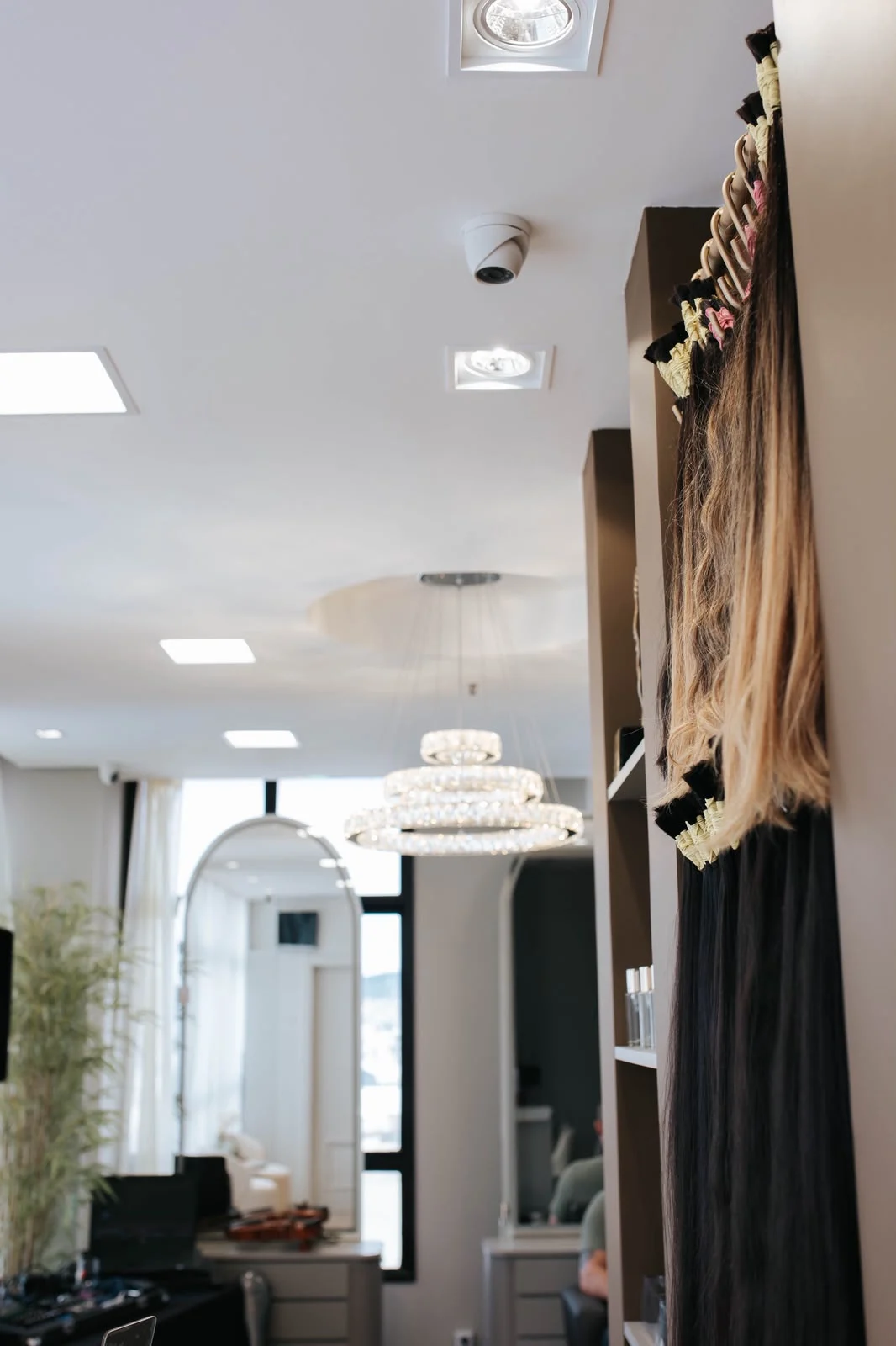Interior do Studio Jéssica Mendes com lustre de cristal e mostruário de mechas